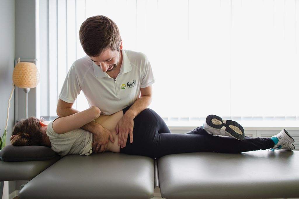Fizjoterapeuta podczas terapii manualnej na odcinku lędźwiowym kręgosłupa u pacjenta z problemami bólowymi w centrum RehaFit we Wrocławiu.