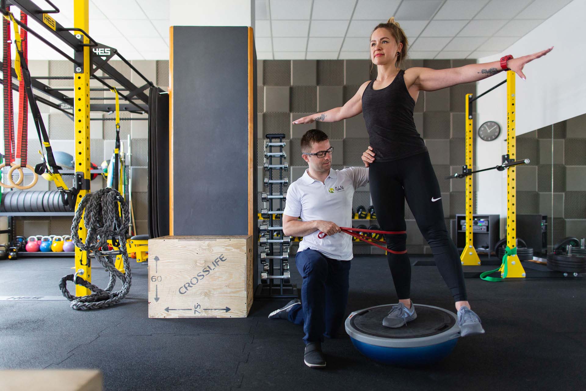 Fizjoterapeuta w trakcie medycznego treningu rehabilitacyjnego mającego na celu poprawę stabilności kończyny dolnej u pacjentki aktywnej fizycznie.